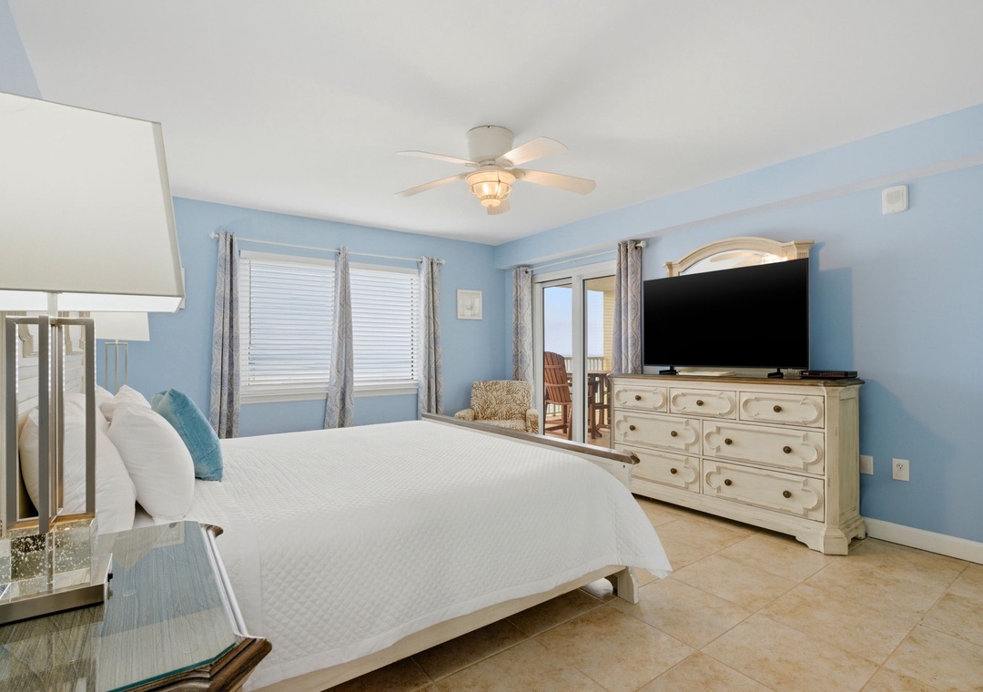 Sandy Key 637- Your serene coastal-inspired bedroom features a plush king bed, soothing blue walls, and ocean breezes from the ceiling fan. Unwind while watching TV or step out to your private balcony.