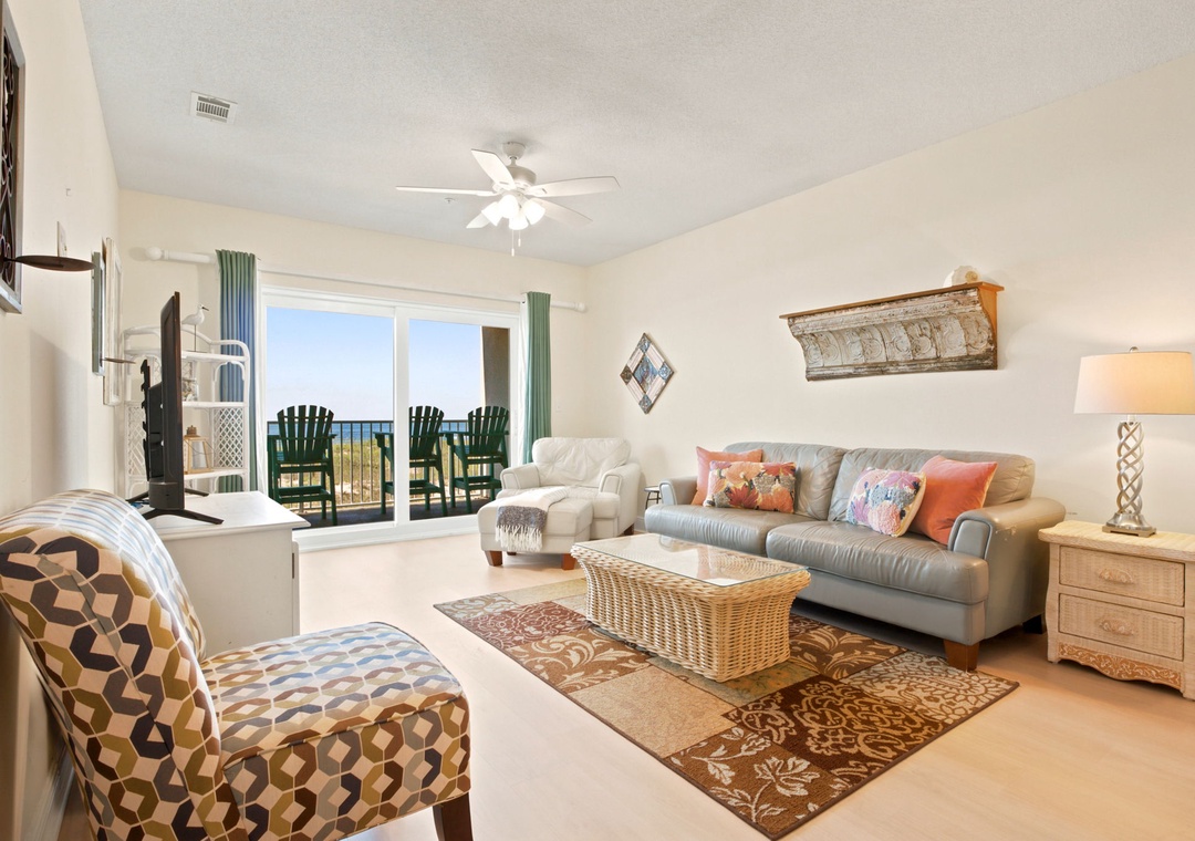Your living room invites relaxation with plush sofas, coastal touches, and a private balcony overlooking serene ocean views—perfect for unwinding after a day of adventure.