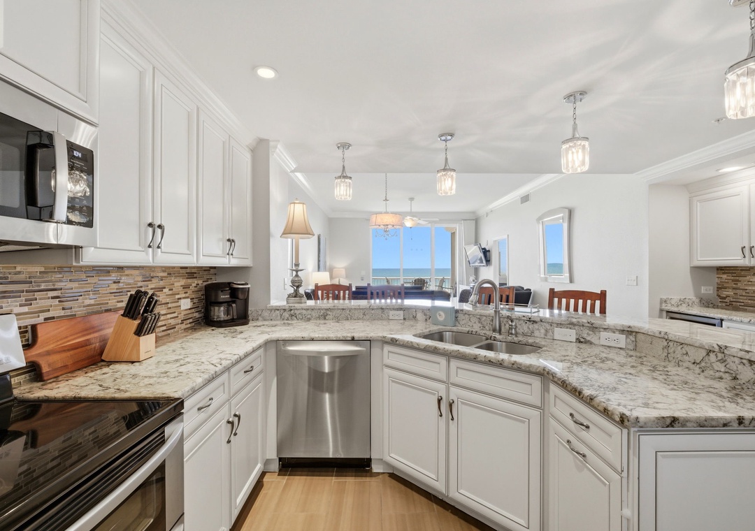 Step into this bright chef's kitchen with granite counters, elegant pendant lighting, and stunning ocean views that stretch across the horizon from every angle.