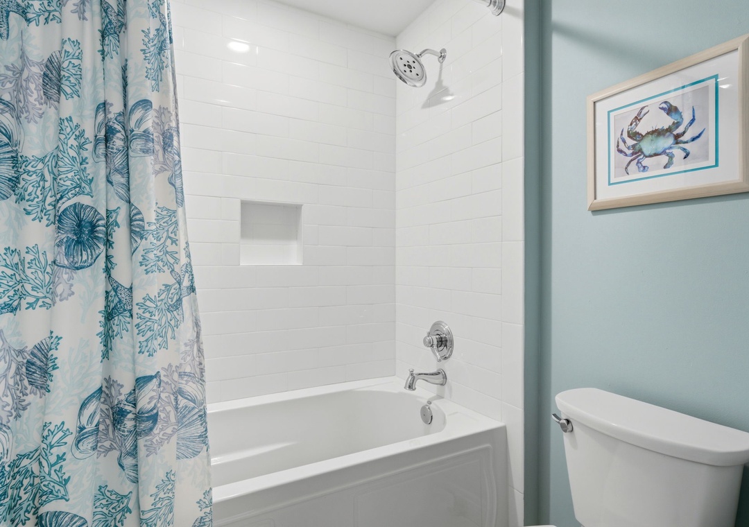 Beach Colony Tower PH1B -Refresh after a day of adventure in your private bathroom with a soaking tub and coastal-inspired décor, including a charming crab print that adds a touch of seaside charm.