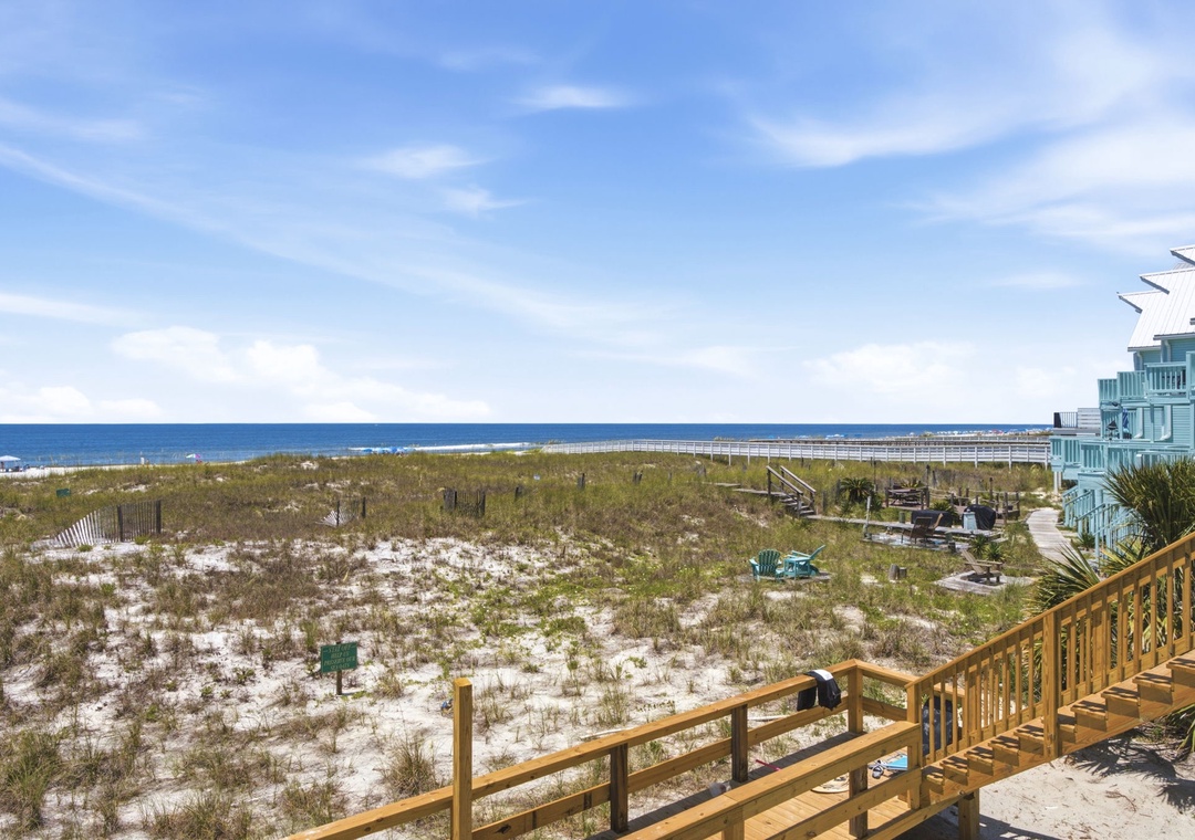 Beachfront property with direct access to pristine white sand dunes and calm blue waters, connected by a scenic wooden boardwalk perfect for morning strolls.