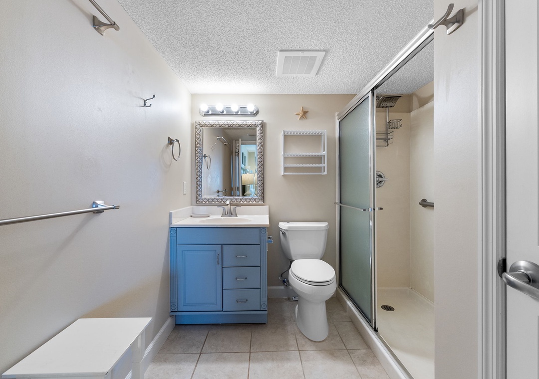 Sandy Key 628- Step into your bright coastal bathroom with beach-inspired accents, a walk-in shower, and a charming blue vanity that adds a pop of color to your daily routine.