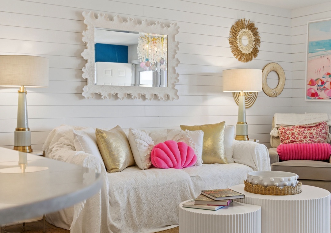 North Lost Key Landing B2- Sink into plush seating surrounded by coastal charm—white shiplap walls, gold accents, and playful pops of pink invite you to unwind in style.