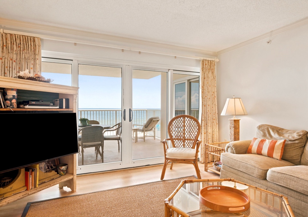 Sandy Key 338- Unwind in your bright, coastal-style living room with sliding glass doors opening to a private balcony overlooking endless ocean views—a perfect retreat for morning coffee or sunset watching.