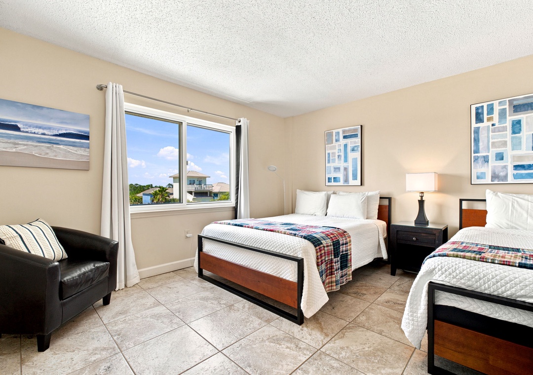 Sandy Key 411- Your bright bedroom features two comfortable beds with crisp linens and plaid throws, plus a cozy reading chair by the window to enjoy Florida sunshine.