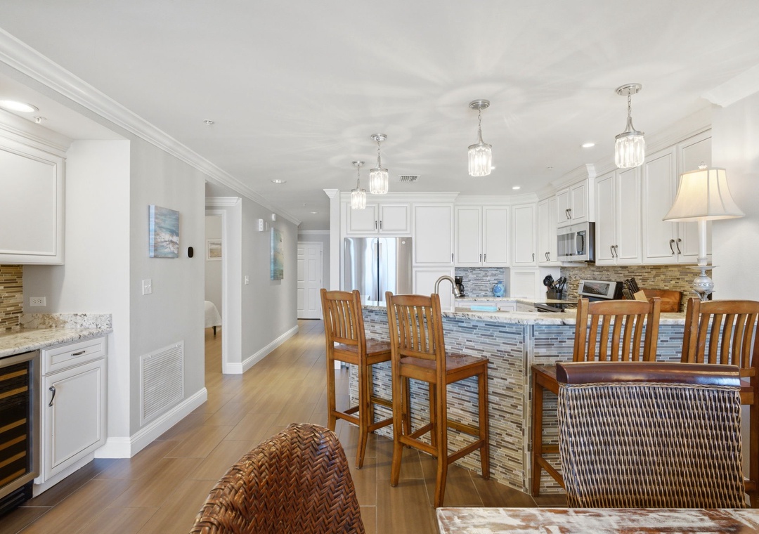 Gather around the spacious kitchen island with elegant pendant lighting, perfect for preparing meals and sharing stories. The bright, open layout and modern appliances make cooking effortless.