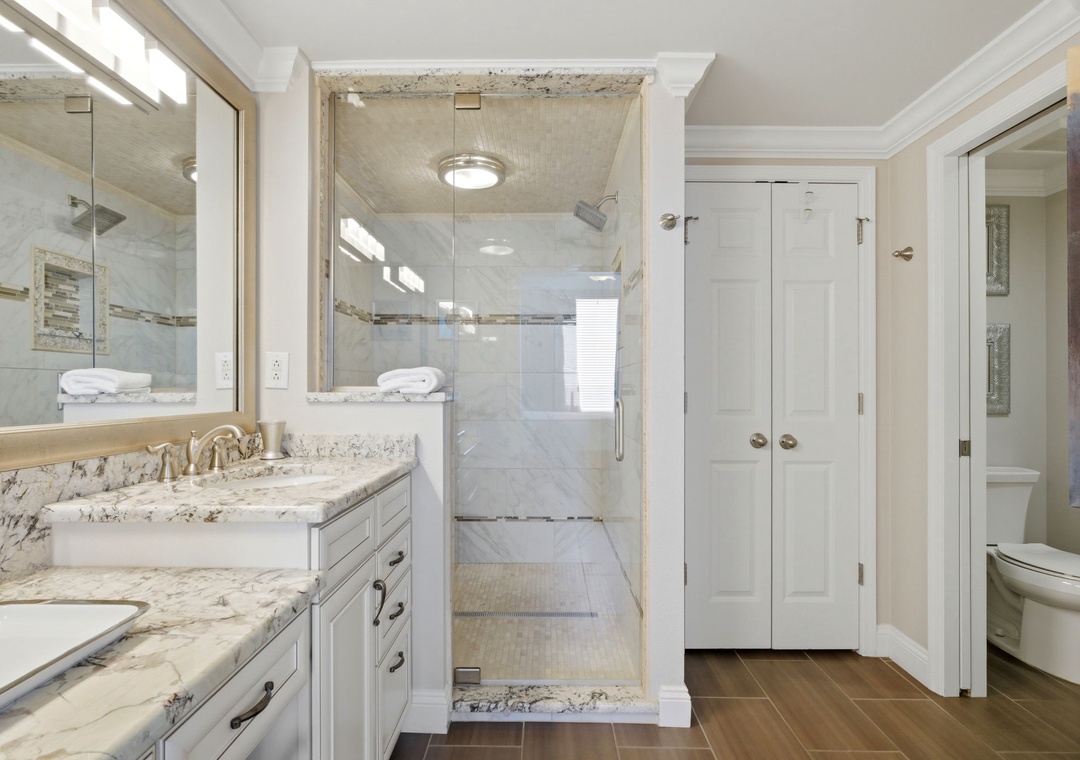 Step into your private spa-like retreat, where a spacious walk-in shower with elegant marble details and a dual-sink vanity invite you to unwind. Bright, clean, and designed for your comfort.
