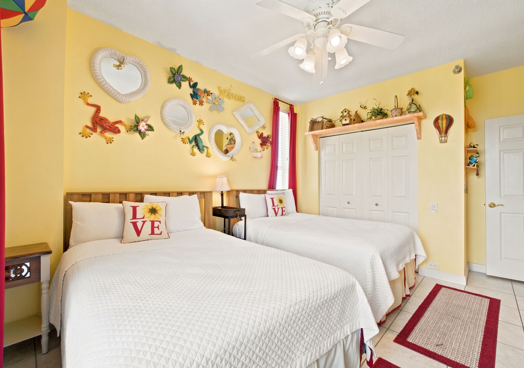Beach Colony W13A- Bright, cheerful bedroom with two plush beds and playful décor. Perfect for families or friends traveling together, with plenty of space to unwind after a day of adventure.