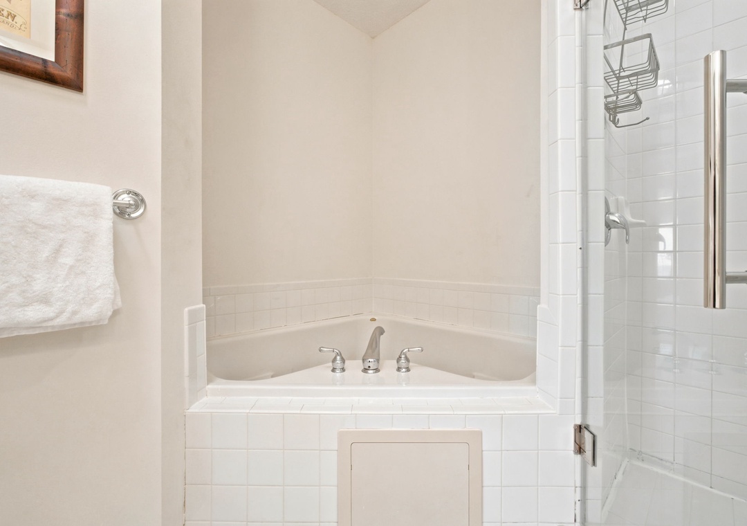 Unwind in your private soaking tub or refresh in the separate glass-enclosed shower, where crisp white tile and soft towels await your arrival.