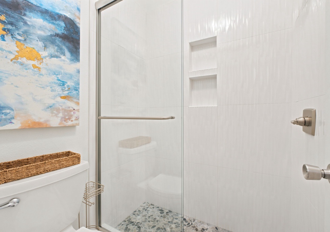 Gulfside Villas 2B- Step into your private spa-like shower with textured stone flooring, built-in shelving, and rainfall showerhead—designed to refresh and rejuvenate you each day.