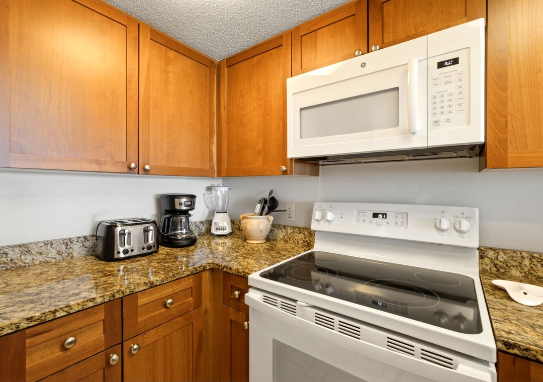 Ocean Breeze W 105- Your kitchen comes fully equipped with everything you need to prepare meals during your stay, including a stove, microwave, and coffee maker, all set against warm wood cabinetry and granite countertops.
