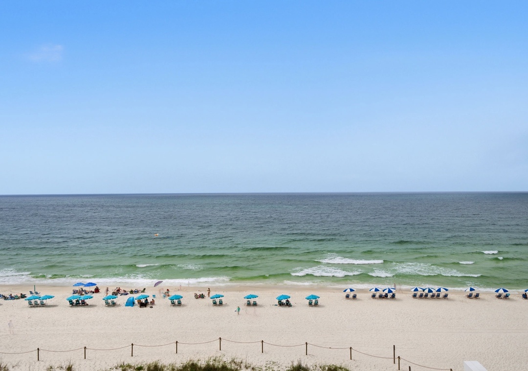 Sandy Key 637- A pristine beach with soft sand meets emerald-green waves along the Gulf Coast, inviting relaxation under umbrellas or exploration along the shoreline.