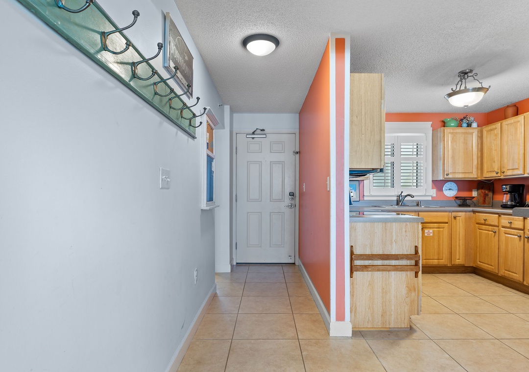 Sandy Key 338- Step into your bright, open kitchen space with warm wood cabinetry and cheerful coral accents—a welcoming spot to prepare meals and gather during your stay.