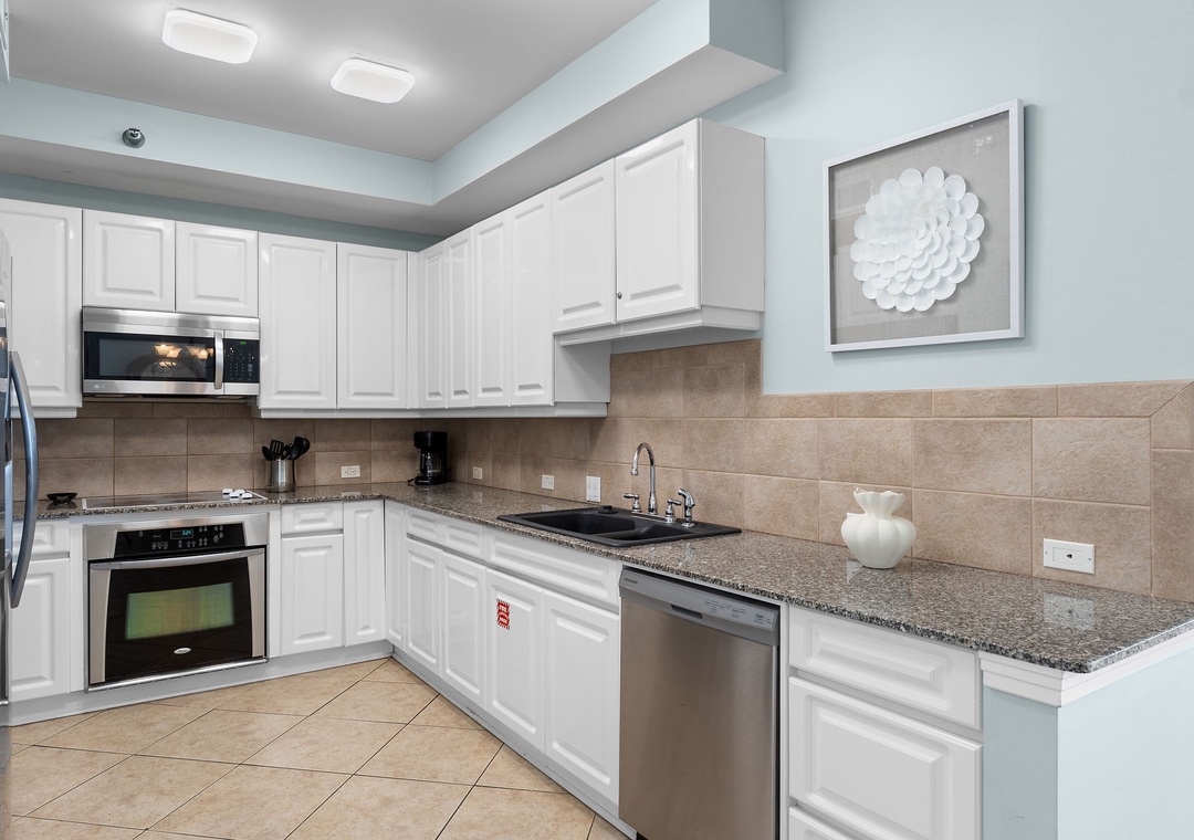 Beach Colony Tower 10C- Your spacious kitchen awaits with stainless steel appliances, granite countertops, and crisp white cabinetry. Everything you need to cook up memorable vacation meals.