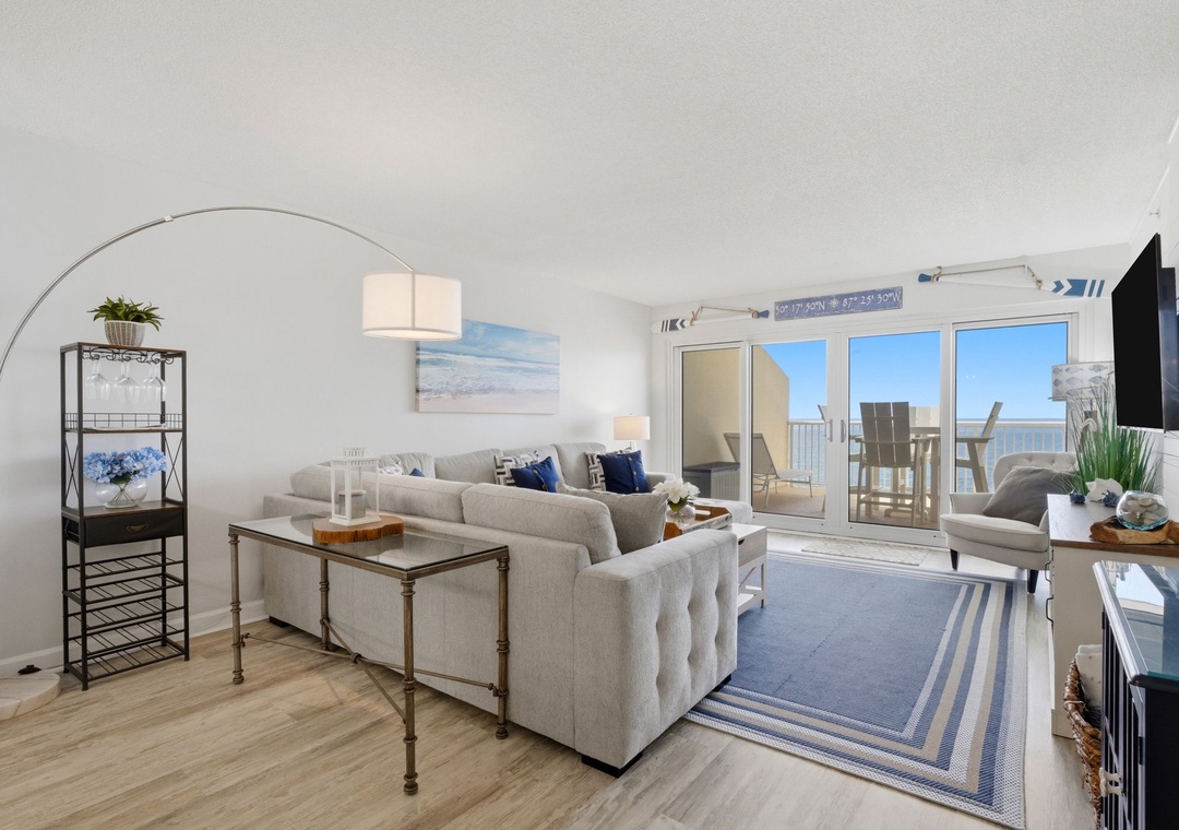 Relax in your beautifully appointed living room, where coastal elegance meets comfort. Floor-to-ceiling doors open to your private balcony, inviting ocean breezes and stunning sea views into your coastal retreat.