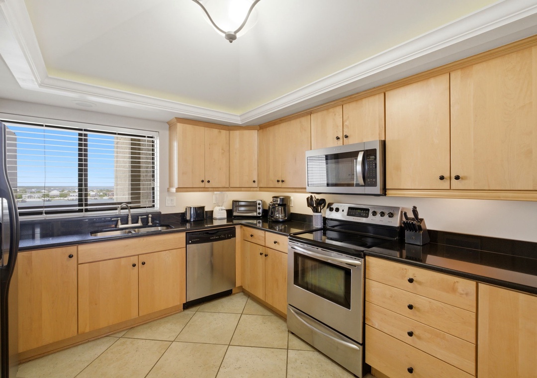Shipwatch D803- Your modern kitchen features sleek stainless appliances, warm maple cabinetry, and a spacious layout perfect for preparing meals while taking in mountain views through the window.