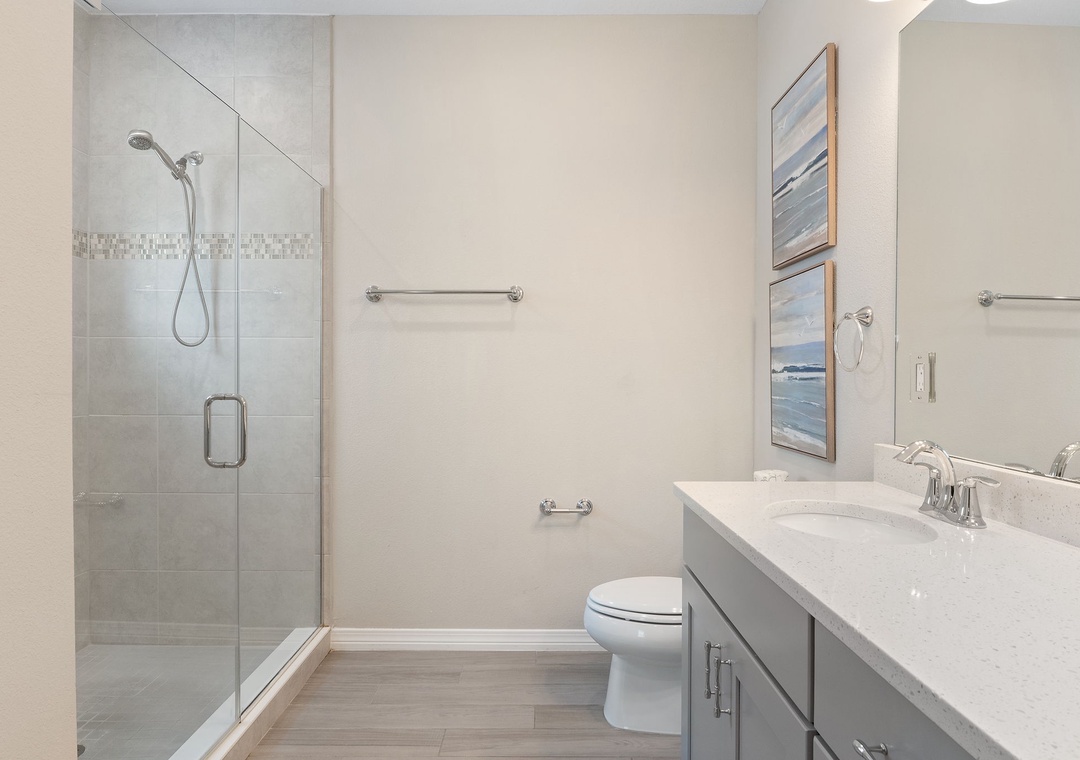 Saltwater & Sunsets- Step into your private spa-like bathroom, where sleek tile and modern fixtures create the perfect retreat after a day of exploring.