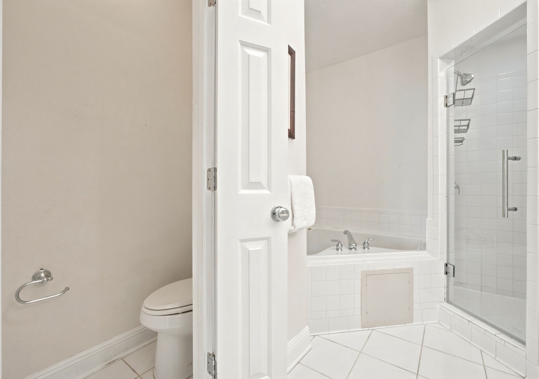 Your private bathroom features fresh white tile, a tub with clean lines, and a separate shower—all designed for your comfort and relaxation.