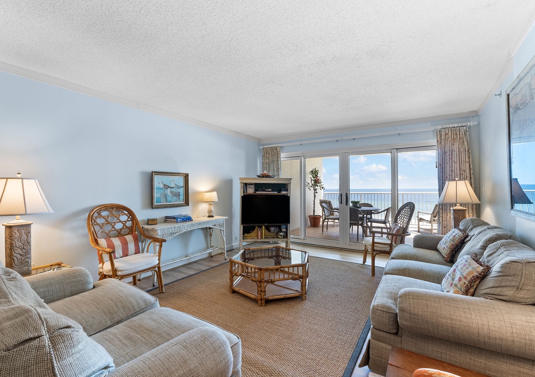 Sandy Key 338- Settle into this bright, airy living room where soft coastal hues and plush seating invite you to relax while the ocean stretches endlessly before you through expansive sliding doors.