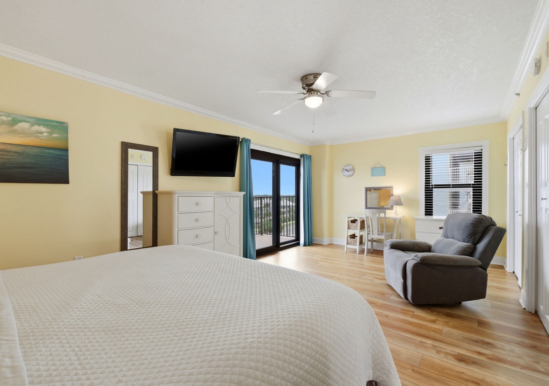 Ocean Breeze E601-Your spacious bedroom features a plush bed, cozy seating area, and sliding doors opening to your private balcony—perfect for morning coffee or evening relaxation.
