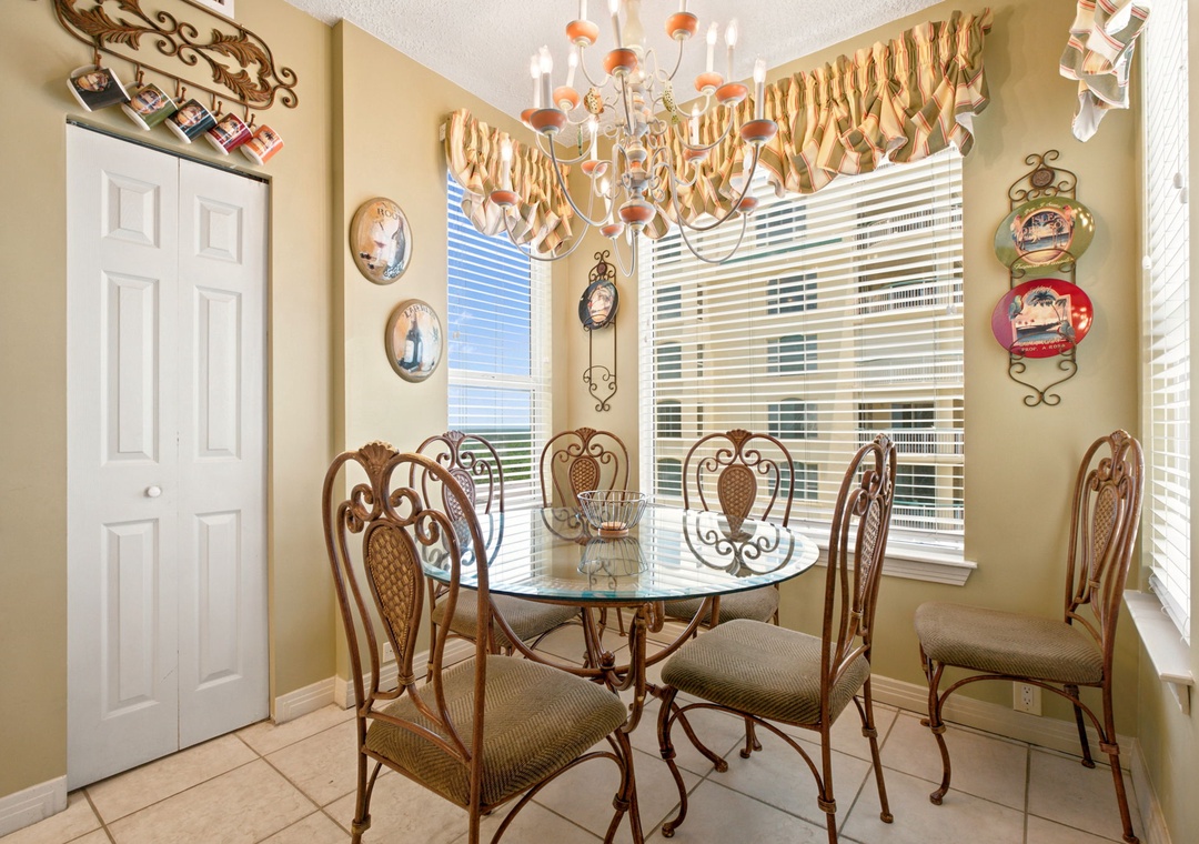 Beach Colony W13A- Gather around this charming dining table for memorable meals together. Large windows flood the space with natural light, creating a warm and inviting atmosphere for your family dinners.