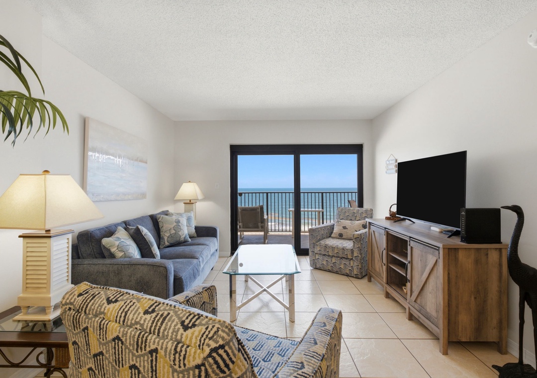 Ocean Breeze E702- Relax in your coastal living room where a comfortable sofa, stylish chairs, and modern entertainment await. Step through the balcony doors to breathe in fresh ocean air and soak in endless blue horizon views.