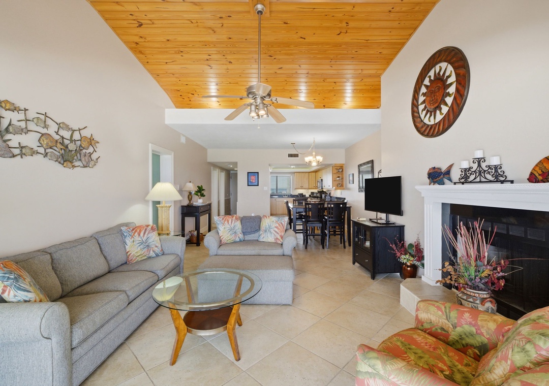 Shipwatch D803- Relax in your spacious living area with vaulted wood ceilings, a cozy fireplace, and vibrant coastal décor. The open floor plan flows seamlessly into the dining and kitchen areas for effortless entertaining.