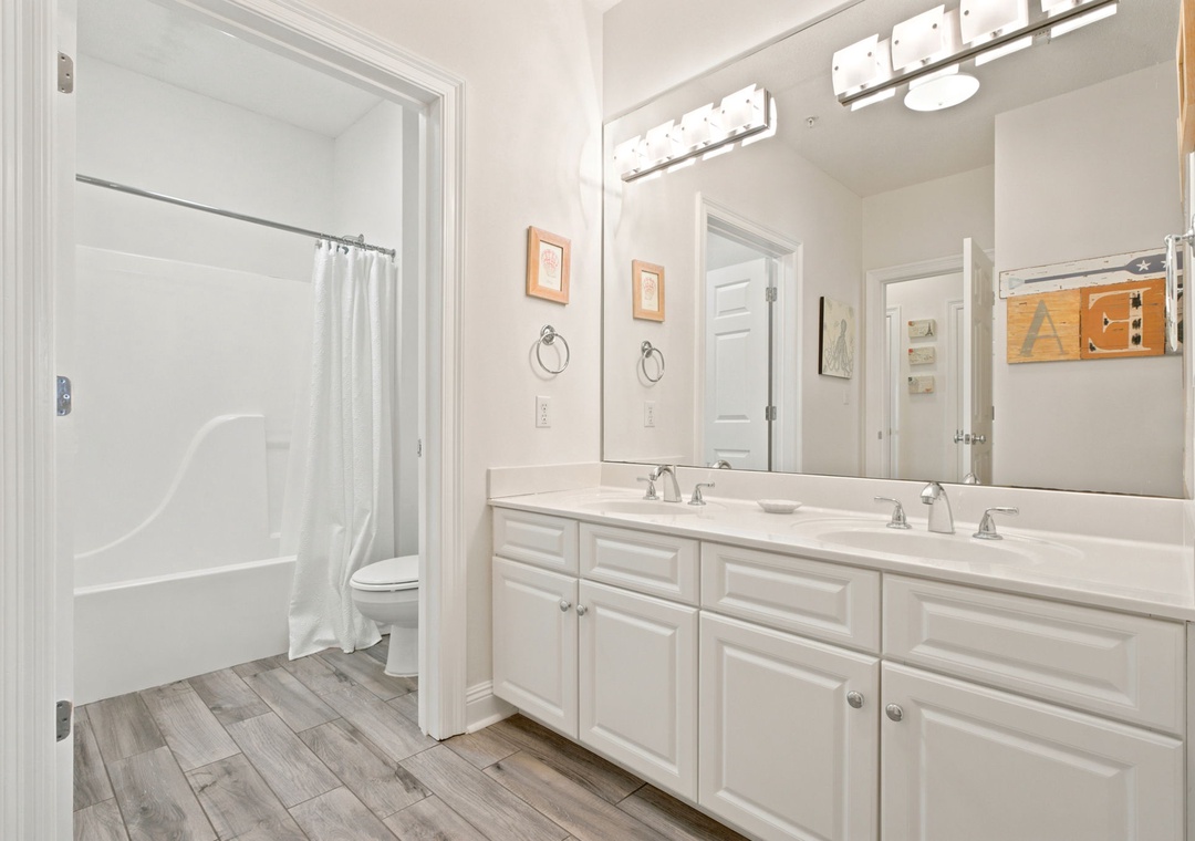 Bright double vanity with ample storage and a shower-tub combo—your space to refresh each morning and unwind after every adventure.