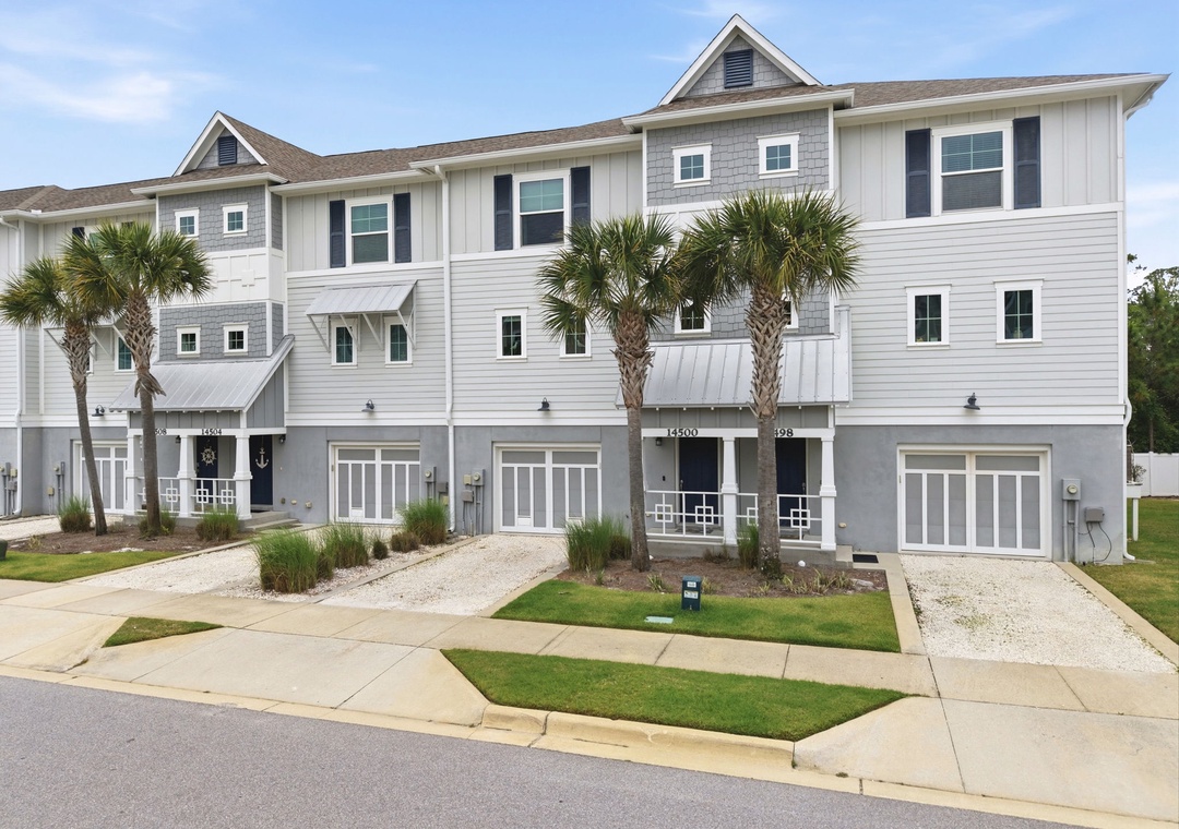 Turtles Nest- Modern coastal townhomes feature inviting facades with tropical landscaping, marking your arrival at this beachside community's charming residential setting.