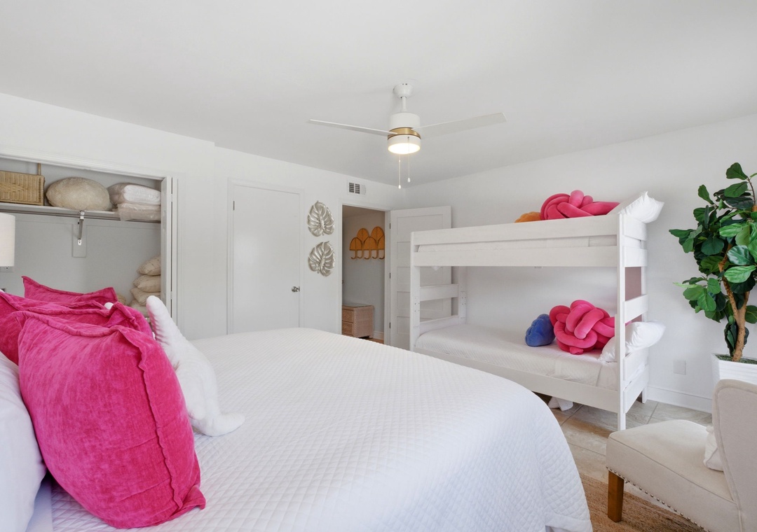 North Lost Key Landing B2- A bright, cheerful bedroom perfect for families—your group can spread out with both a cozy queen bed and white bunks, all bathed in natural light beneath a refreshing ceiling fan.