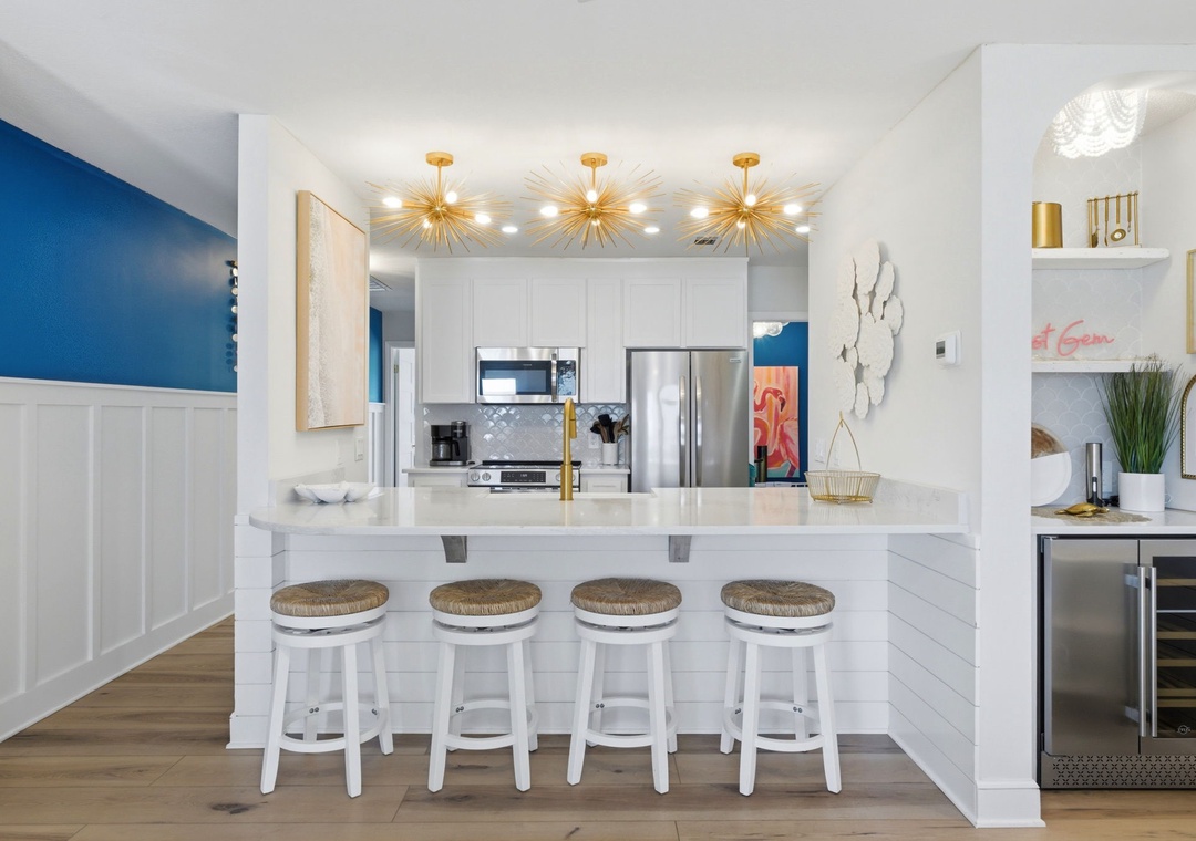 North Lost Key Landing B2- Gather around this sleek breakfast bar where modern elegance meets coastal charm. Golden starburst fixtures illuminate your morning coffee .