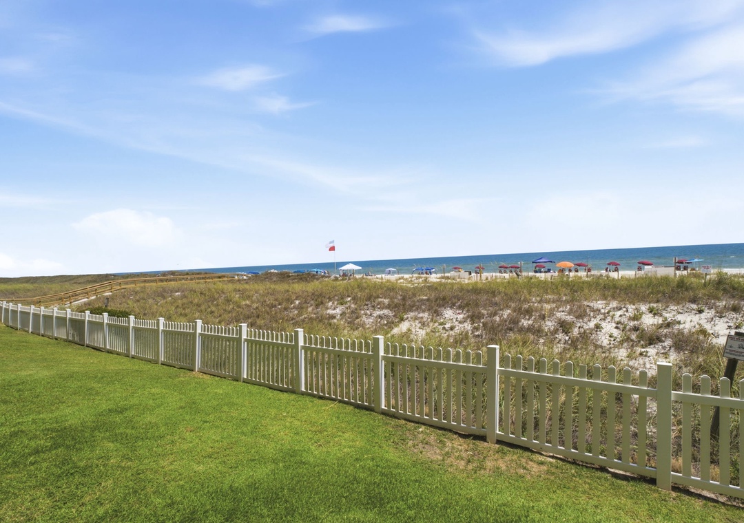 Ocean Breeze W 105- The property borders natural dunes and beach access, with the Gulf waters stretching toward the horizon. Beachfront location with direct access to sandy shores.