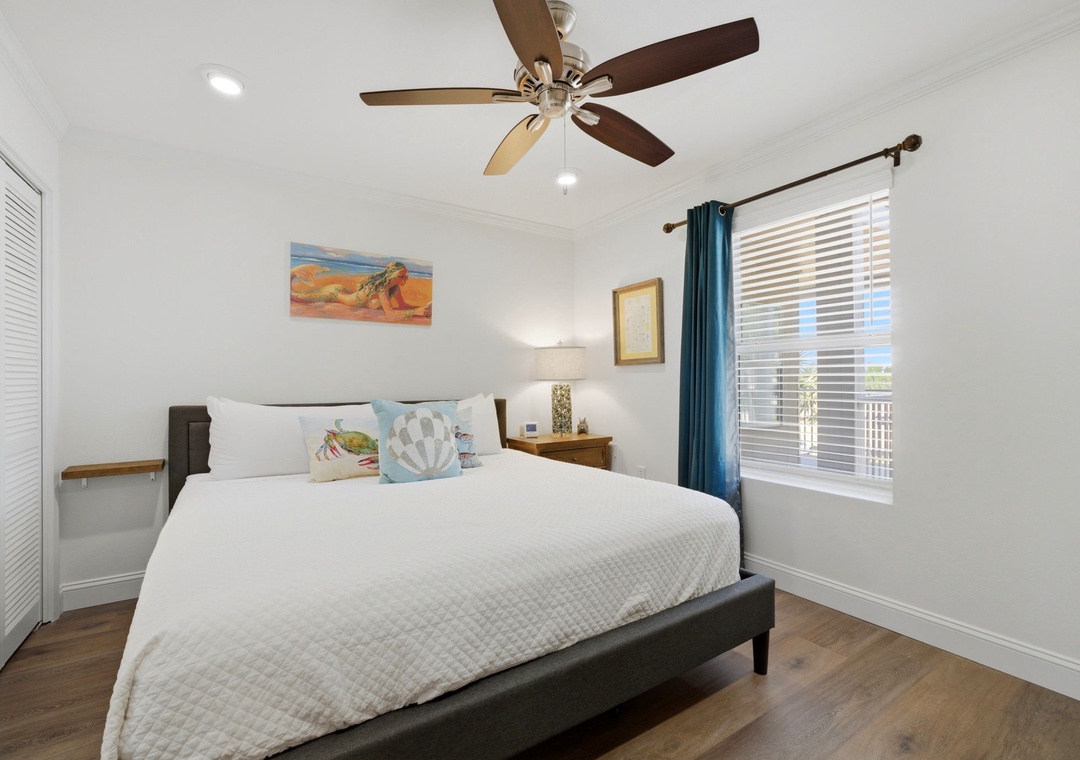 Grand Caribbean 305W- Drift off to sleep in this bright, coastal-inspired bedroom. Your plush bed, gentle ceiling fan, and breezy blue curtains create the perfect retreat after a day of adventure.