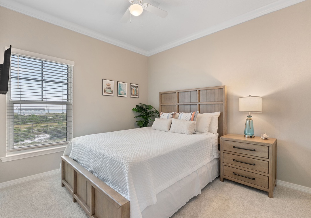 Saltwater & Sunsets- Drift off in this calming bedroom, where soft linens and gentle coastal hues create your perfect retreat. Natural light spills through the window as the ceiling fan hums overhead, keeping you cool and comfortable.