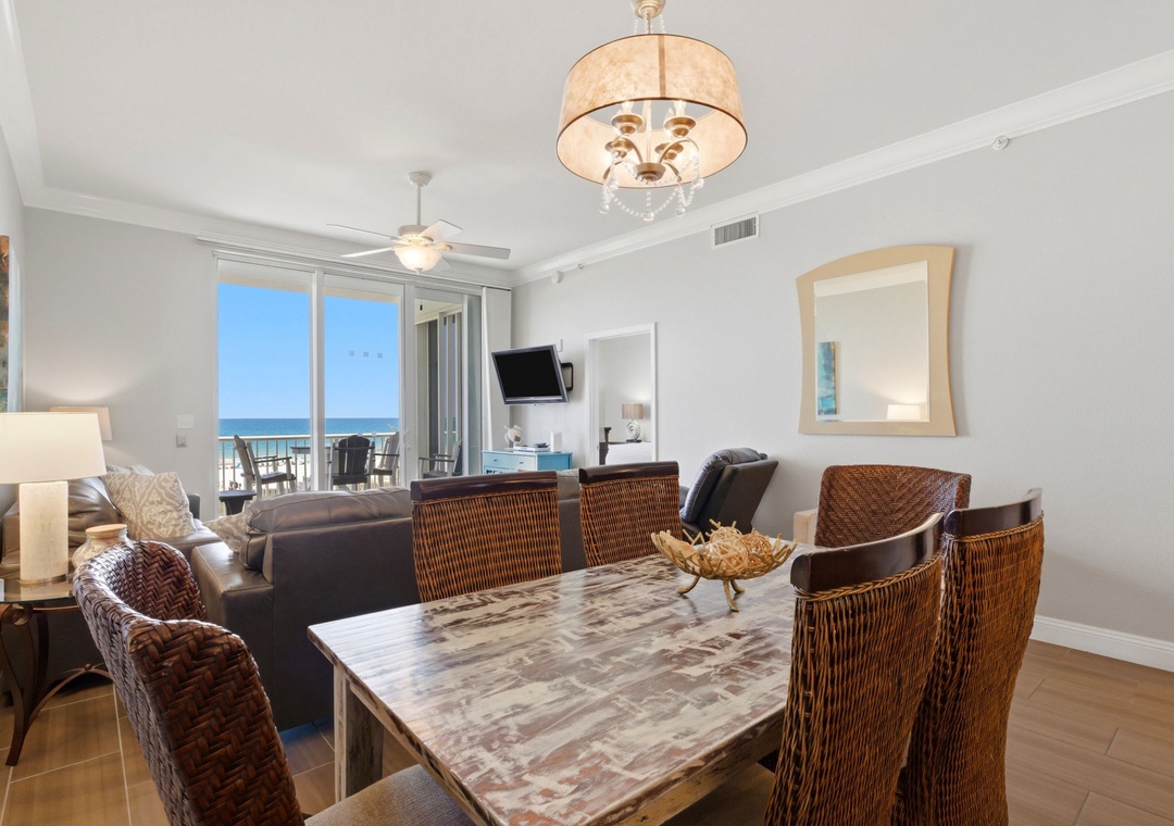 Gather around the spacious dining table while the ocean breeze drifts through your private balcony doors, creating the perfect setting for meals with loved ones in this bright, elegantly furnished coastal retreat.