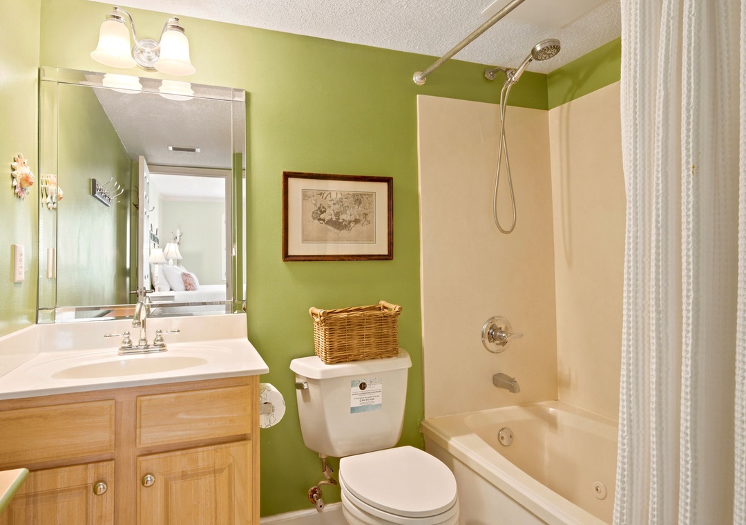 Sandy Key 338- Your private bathroom features a full tub-shower combo, crisp linens, and cheerful green walls that bring a fresh, welcoming vibe to your daily routine.