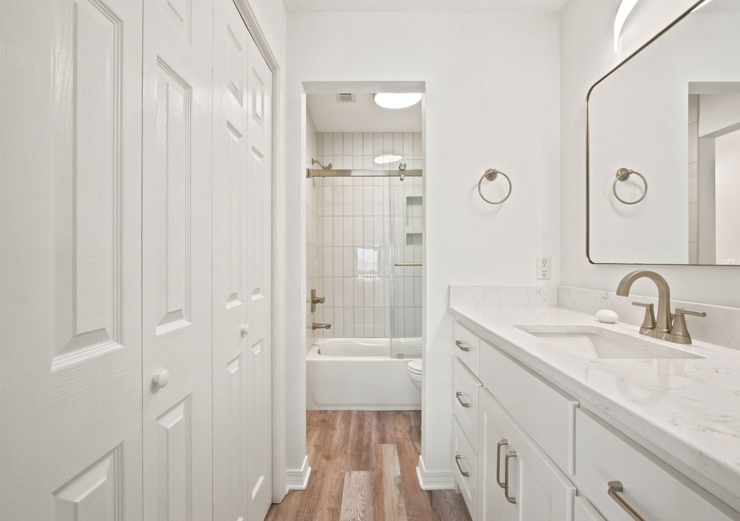 Gulfside Villas 2B- Step into your bright, modern bathroom with dual vanities, marble countertops, and a relaxing shower-tub combo—perfect for unwinding after exploring the area.