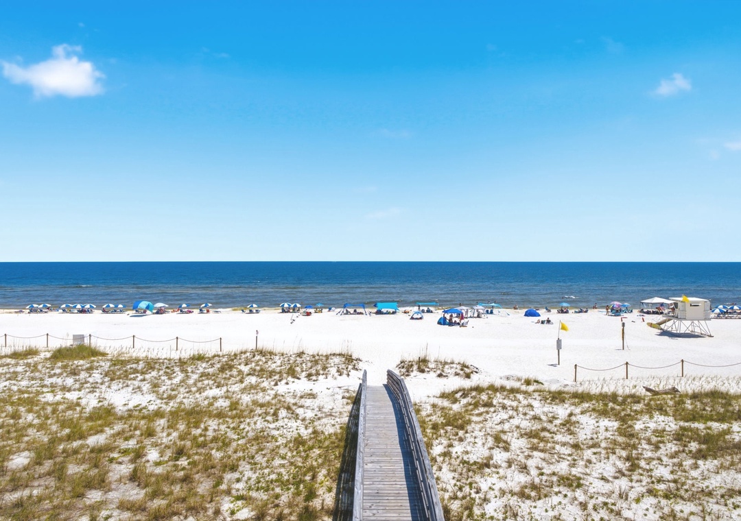 Gulfside Villas 2B- Pristine white sand beach with wooden boardwalk leading to turquoise waters. Part of the surrounding area, offering coastal beauty near the property.