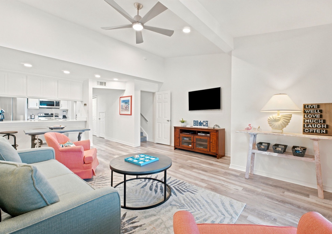 Gulfside VillaPicture yourself relaxing in this bright, beachy living space with vaulted ceilings and coastal charm. Sink into comfy seating while the ceiling fan keeps you cool, and enjoy open views into the kitchen for easy entertaining during your stay