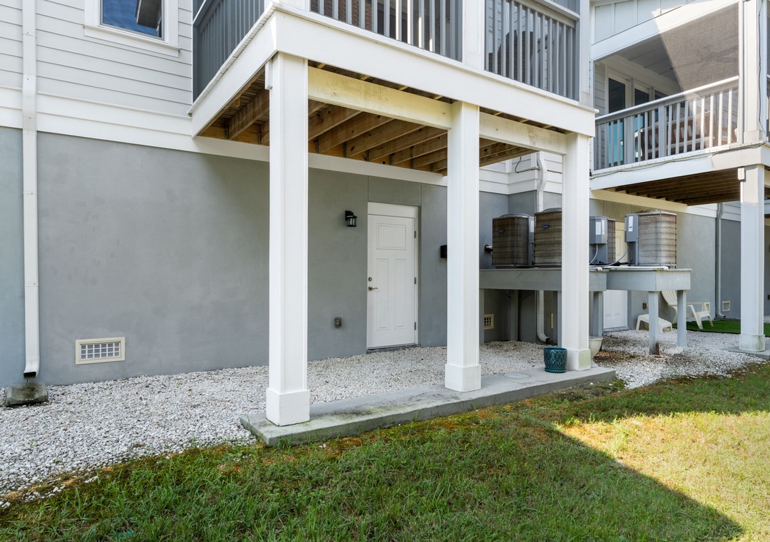 Turtles Nest- Elevated coastal property with covered parking and balconies, surrounded by neighboring homes in a quiet residential area.