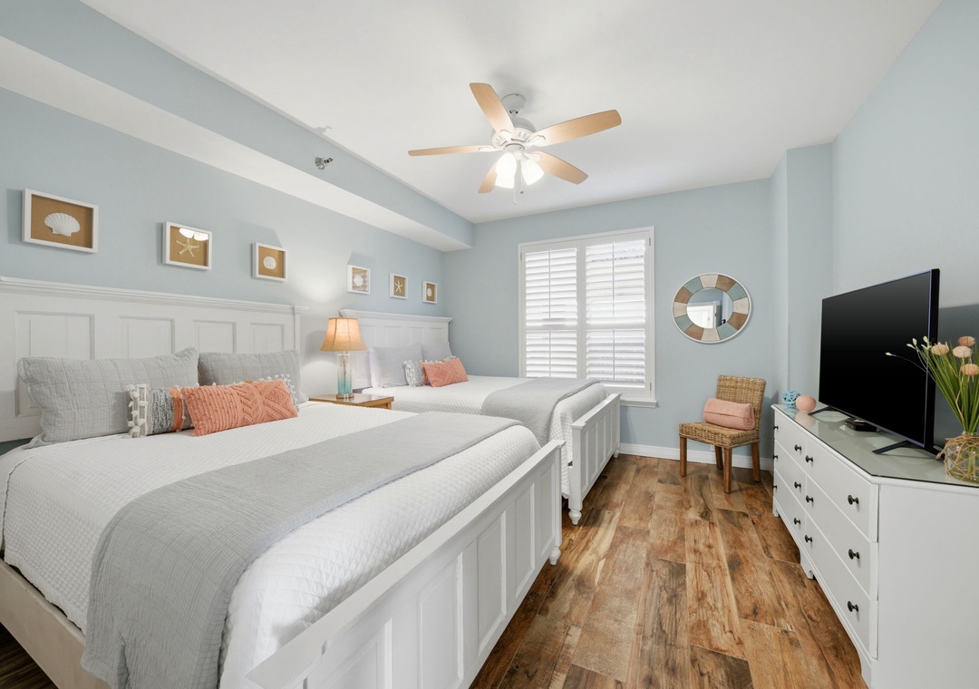 Beach Colony Tower PH1B - Rest easy in this coastal-themed bedroom, where soft blue walls and plush bedding welcome you. Fresh flowers and beach-inspired decor add warmth, making it your perfect retreat.