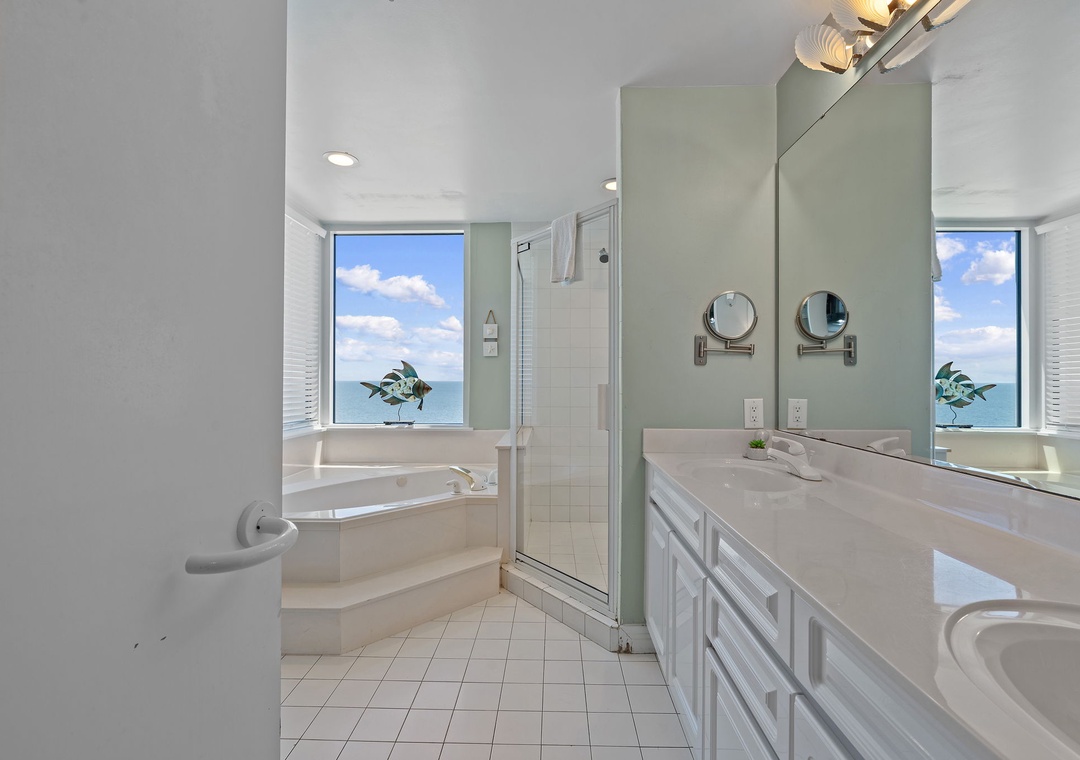 Beach Colony T15B- Unwind in your serene spa-like bathroom with a soaking tub, walk-in shower, and dual vanities—all while enjoying stunning ocean views through expansive windows.