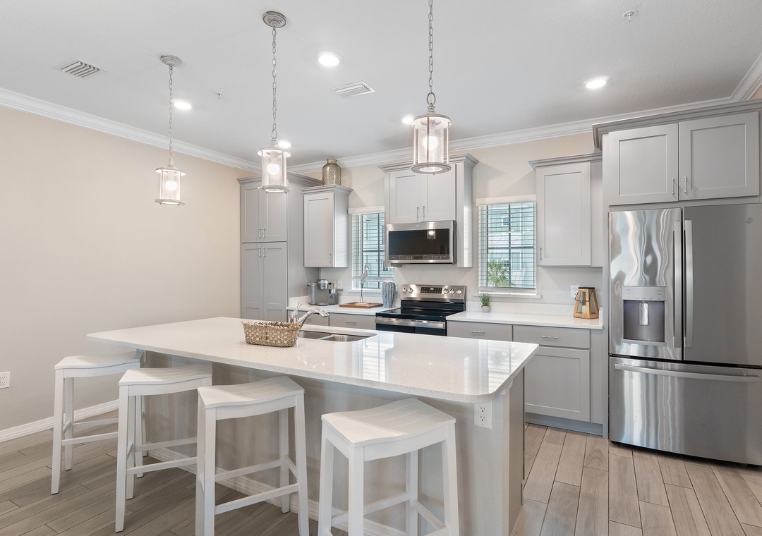 Saltwater & Sunsets- Your bright, modern kitchen awaits with gleaming countertops, top-notch stainless appliances, and casual island seating—perfect for morning coffee or prepping a vacation feast.