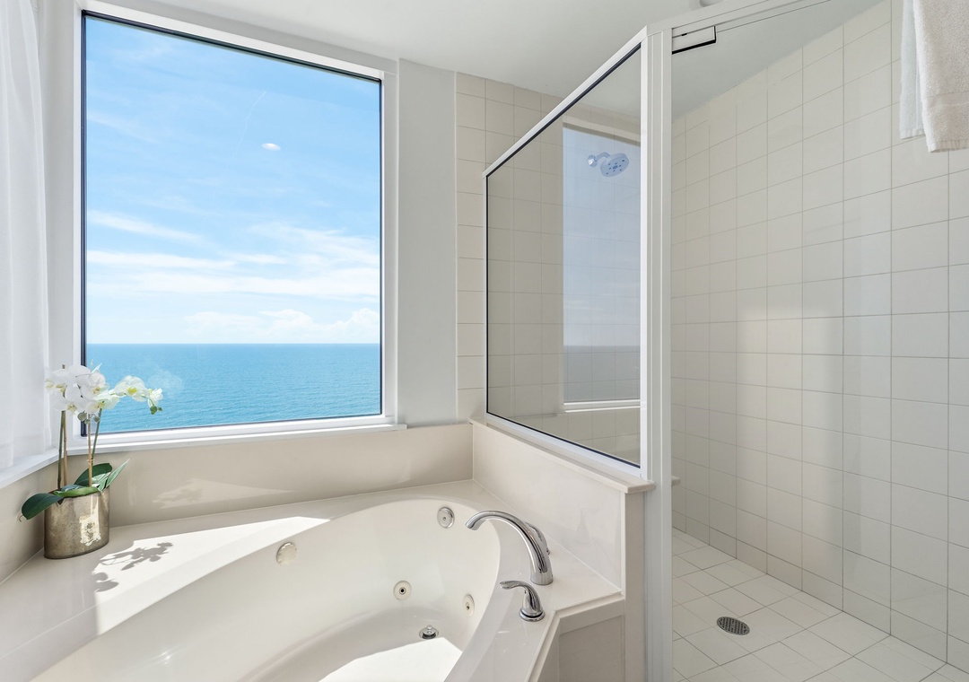 Beach Colony T14B- Soak in the deep tub while gazing at sparkling ocean waves through your private window—a serene escape where relaxation meets breathtaking coastal beauty.