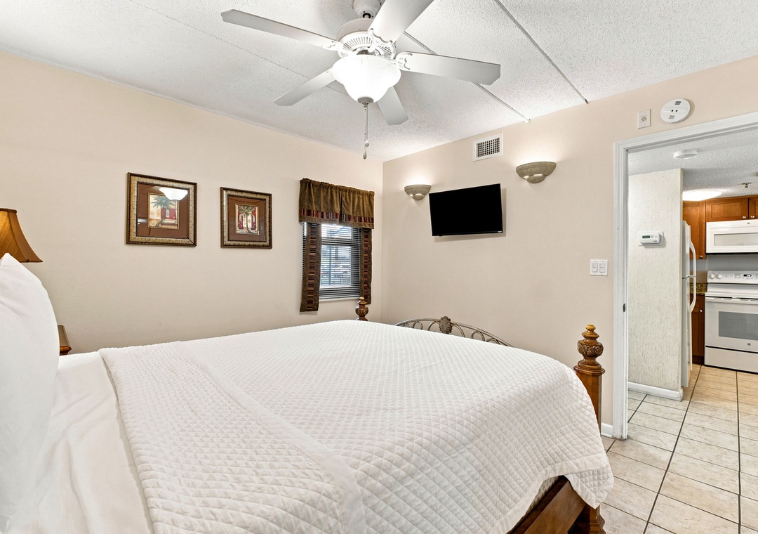 Ocean Breeze W 105- Sink into a cloud-soft bed beneath a gentle ceiling fan, with your own flat-screen TV and easy access to a full kitchen—everything you need for a restful night.