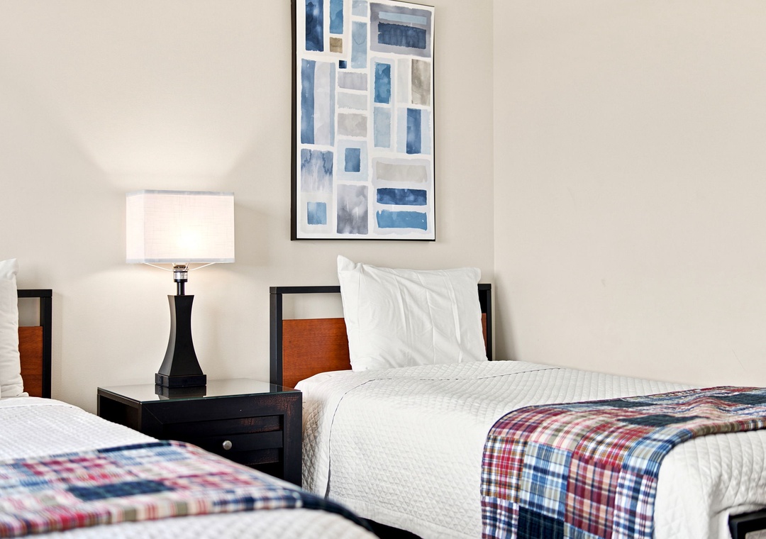 Sandy Key 411- Bright bedroom with two comfortable twin beds dressed in crisp linens and cheerful plaid throws invites restful nights.