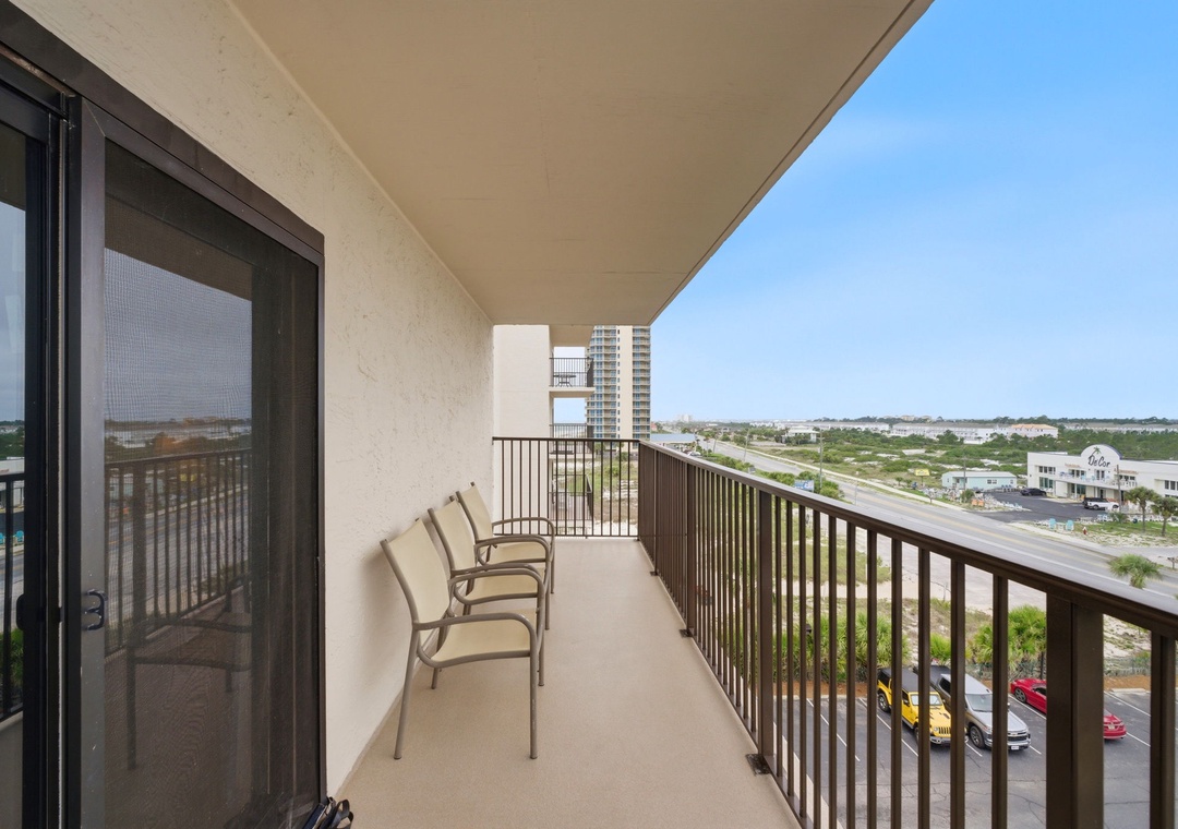 Ocean Breeze E601- A private balcony on a mid-rise level offers elevated views over the city's rooftops, distant landscapes, and nearby roadways—a quiet outdoor space to enjoy the surrounding area.