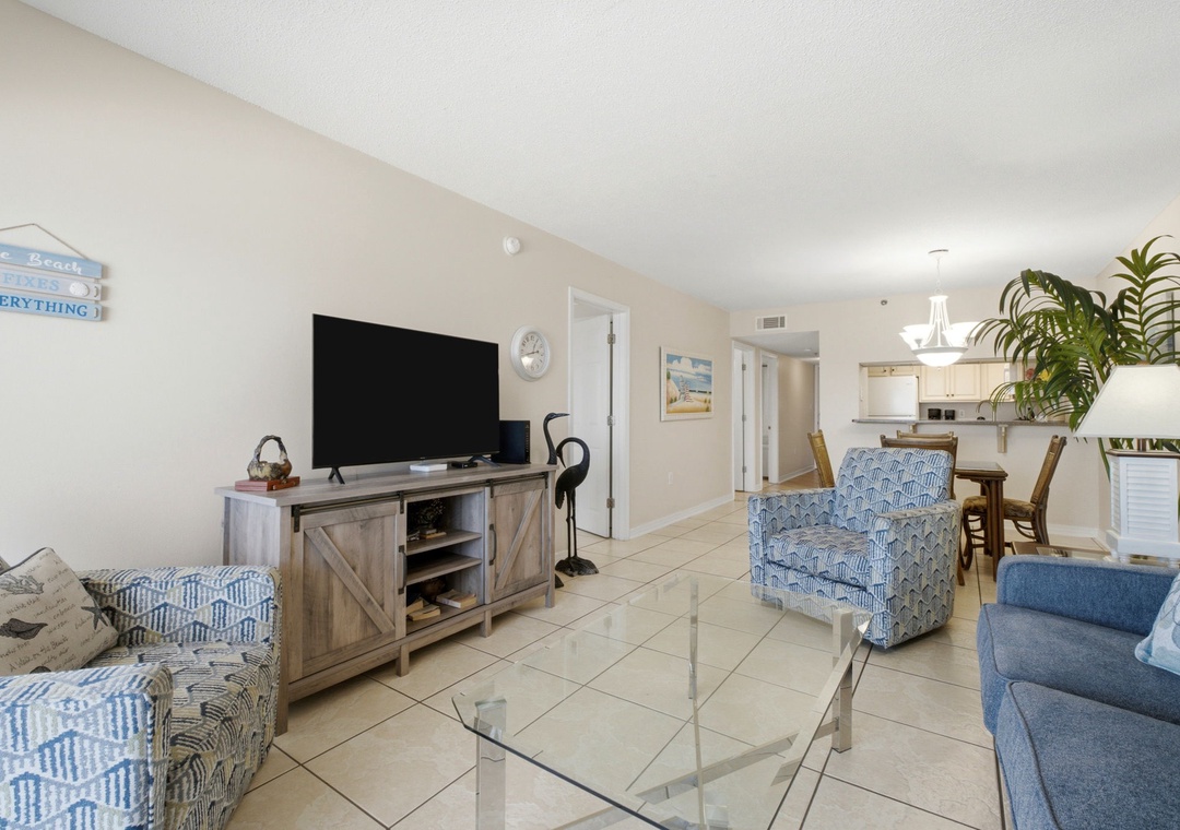 Ocean Breeze E702- Step into your bright, breezy living space where coastal blues meet comfort. Relax with a movie on the large TV or gather around the dining table—your beach getaway starts here.