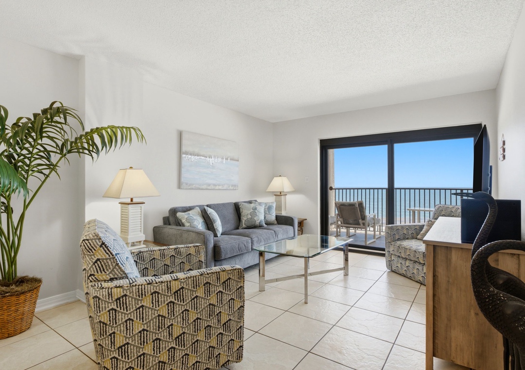 Ocean Breeze E702- Picture yourself unwinding in this bright, coastal living room—plush seating, soft natural light, and stunning ocean views from your private balcony create the perfect beach escape.