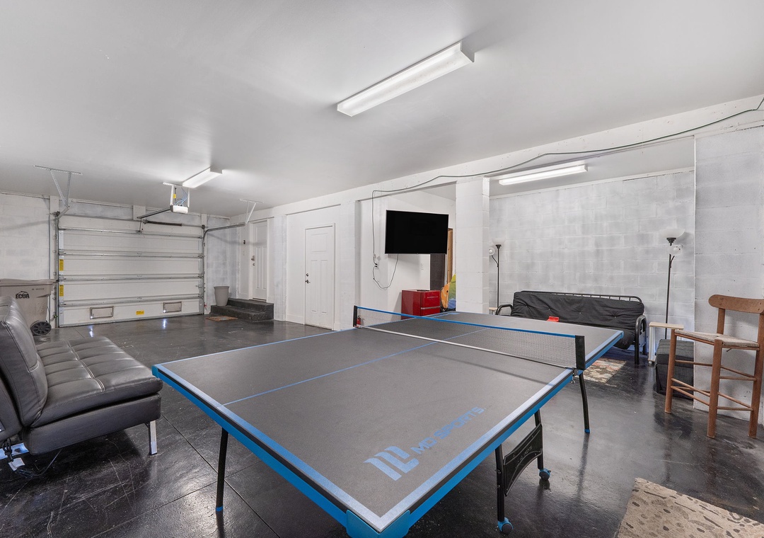 Saltwater & Sunsets- Your private game room awaits in this spacious garage-style area, featuring a full-size table tennis setup and lounge seating for friendly competition and downtime between matches.